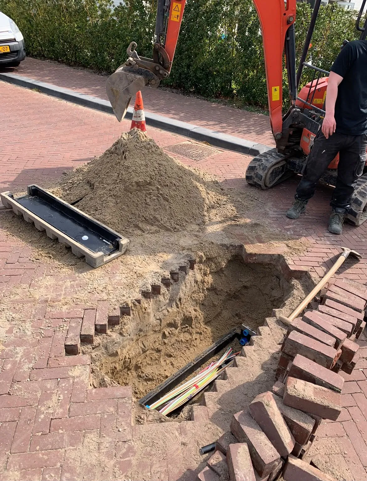 Medewerker werkt in een kabelput
