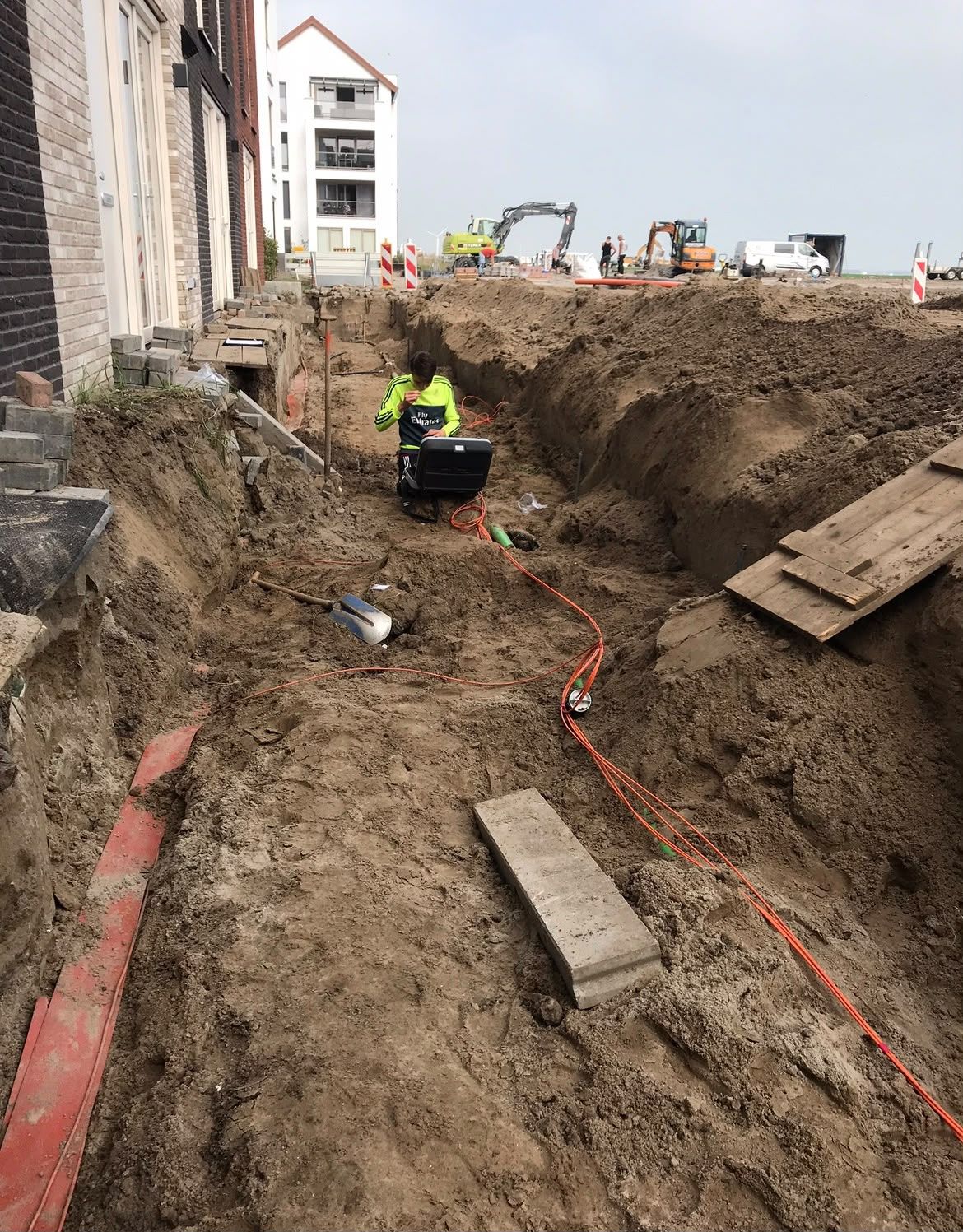 Monteur aan het werk in een open kabelsleuf