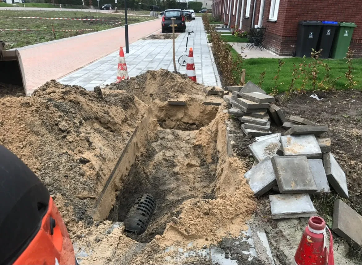 Opengewerkte kabelput in een woonwijk
