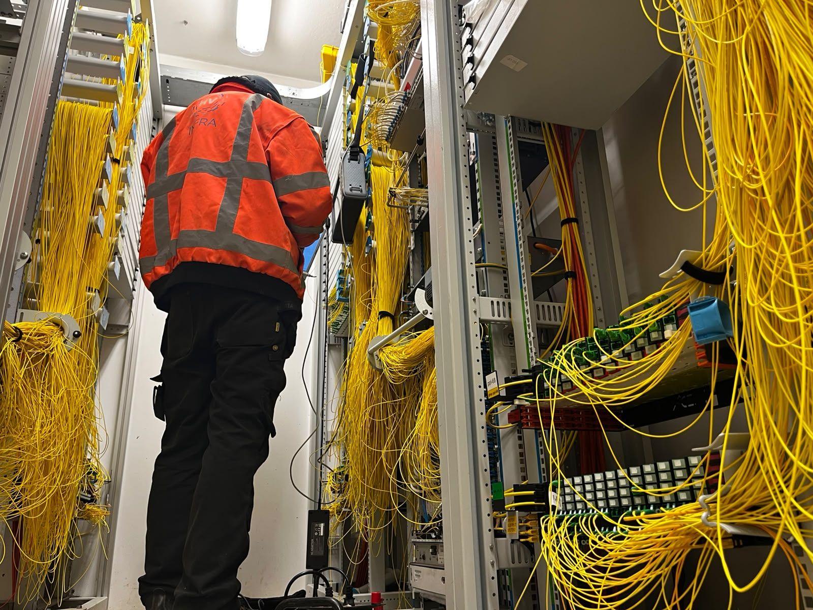 Monteur gebogen bezig met montagewerk in een technische ruimte