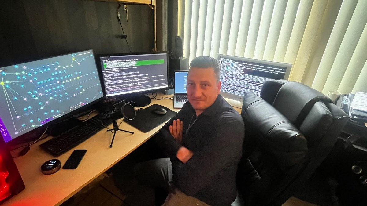 De oprichter van HV Infra achter de computer met meerdere schermen waarop het zelfgebouwde automatiseringsplatform draait