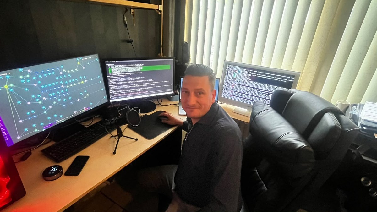 De oprichter van HV Infra aan zijn werkplek met meerdere monitoren waarop het platform draait