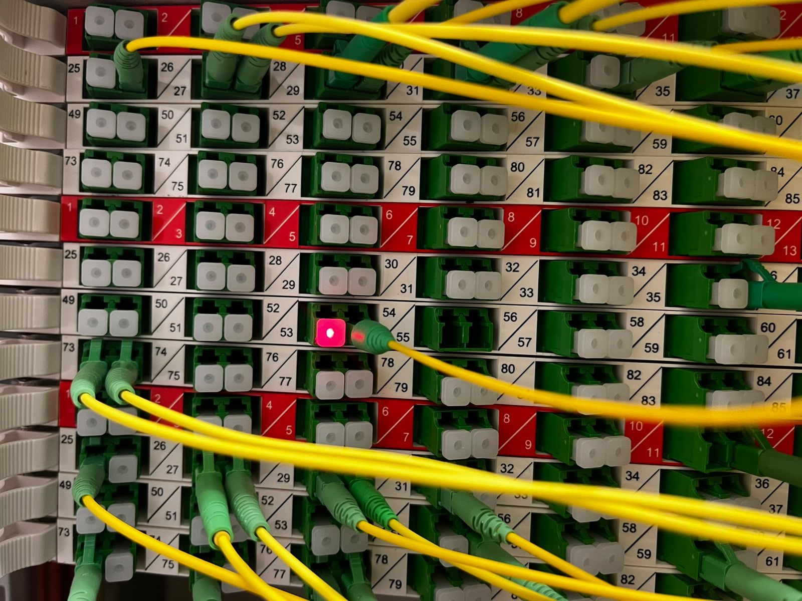 Rood laserlicht van een VFL-tester zichtbaar in een glasvezelpaneel
